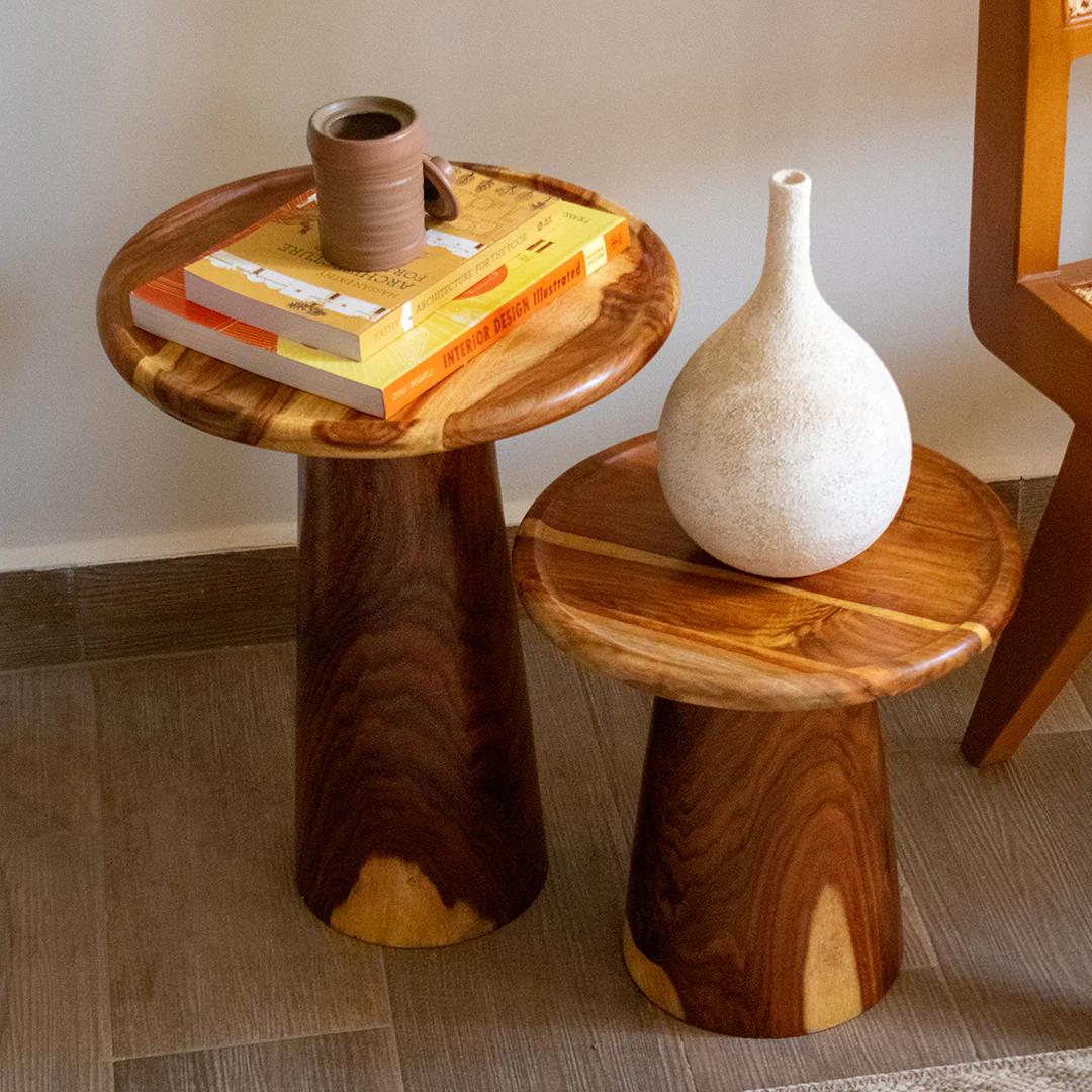Two wooden side tables with decorative items on a tiled floor.