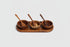 Set of three wooden bowls with spoons on a wooden tray against a white background