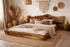 Cozy bedroom with wooden bed, pillows, and decorative elements.